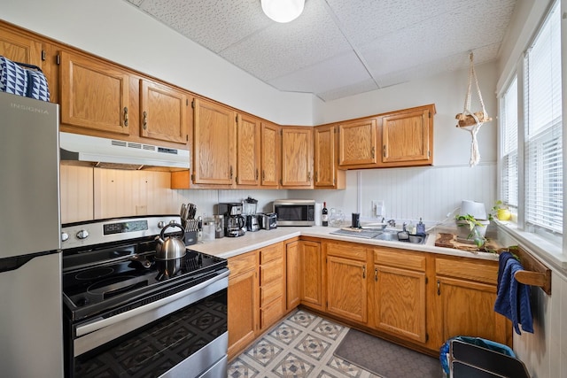 572 Walnut Ave, Elgin, IL 60123 - kitchen featuring appliances with stainless steel finishes, under cabinet range hood, a drop ceiling, light countertops, and a sink