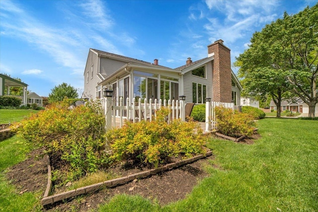 731 Viola Ct, Schaumburg, IL 60194 - back of house featuring a chimney, a yard, and a sunroom