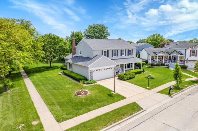 731 Viola Ct, Schaumburg, IL 60194 - traditional home featuring an attached garage, stone siding, a front lawn, a chimney, and driveway