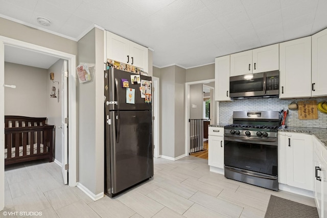 41672 N Dot Pl, Antioch, IL 60002 - kitchen featuring stainless steel appliances, white cabinets, decorative backsplash, dark stone countertops, and baseboards