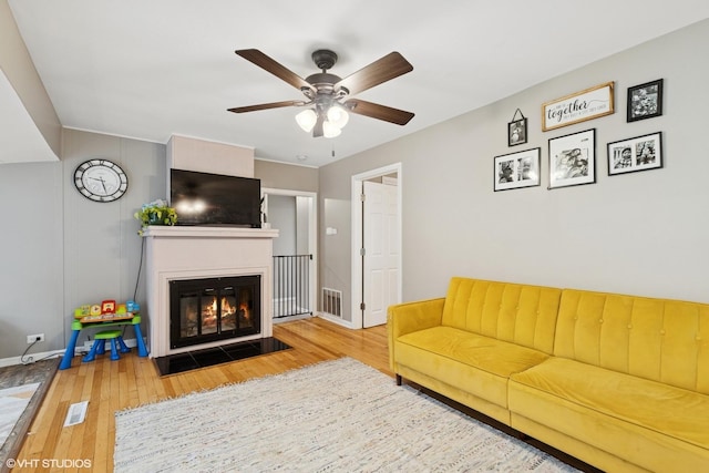 41672 N Dot Pl, Antioch, IL 60002 - living area featuring wood-type flooring, a fireplace with flush hearth, a ceiling fan, and baseboards