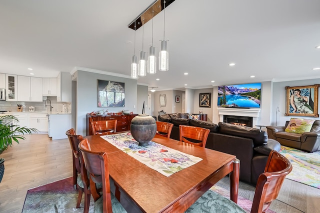 1409 Burr Oak Rd Unit 311A, Hinsdale, IL 60521 - dining area featuring ornamental molding, recessed lighting, light wood-style floors, and a warm lit fireplace