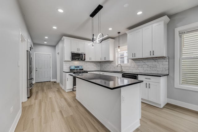 5731 S Damen Ave, Chicago, IL 60636 - kitchen with stainless steel appliances, a sink, dark countertops, light wood finished floors, and tasteful backsplash