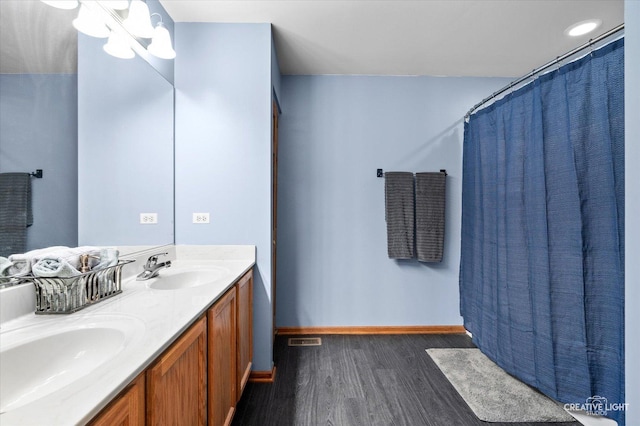 1057 Wright Ct, Plano, IL 60545 - bathroom featuring wood finished floors, double vanity, and baseboards