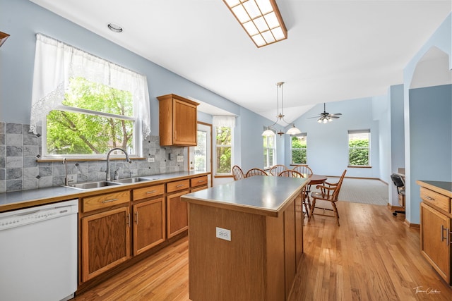 3151 Sawgrass Dr, Aurora, IL 60502 - kitchen featuring white dishwasher, a sink, brown cabinetry, light wood finished floors, and vaulted ceiling
