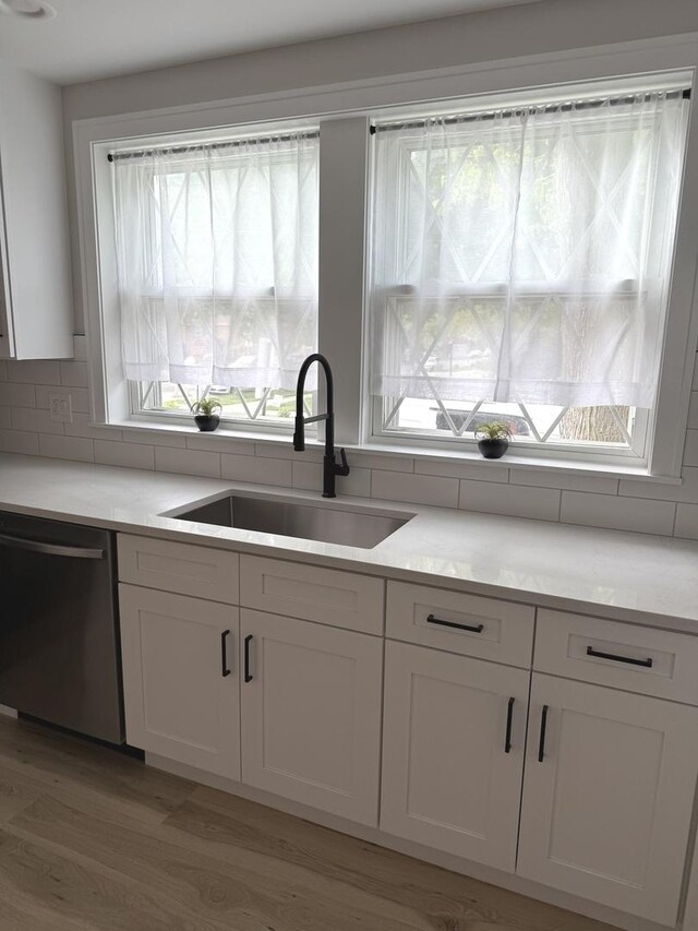 5301 S Mcvicker Ave, Chicago, IL 60638 - kitchen featuring dishwasher, a sink, white cabinetry, and plenty of natural light