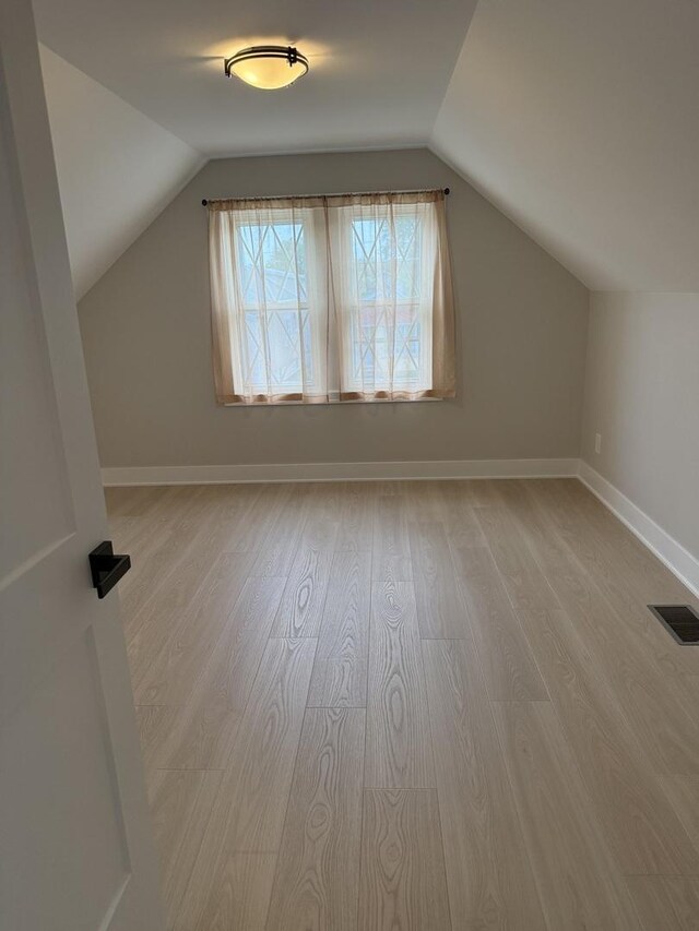 5301 S Mcvicker Ave, Chicago, IL 60638 - additional living space featuring lofted ceiling, light wood finished floors, and baseboards