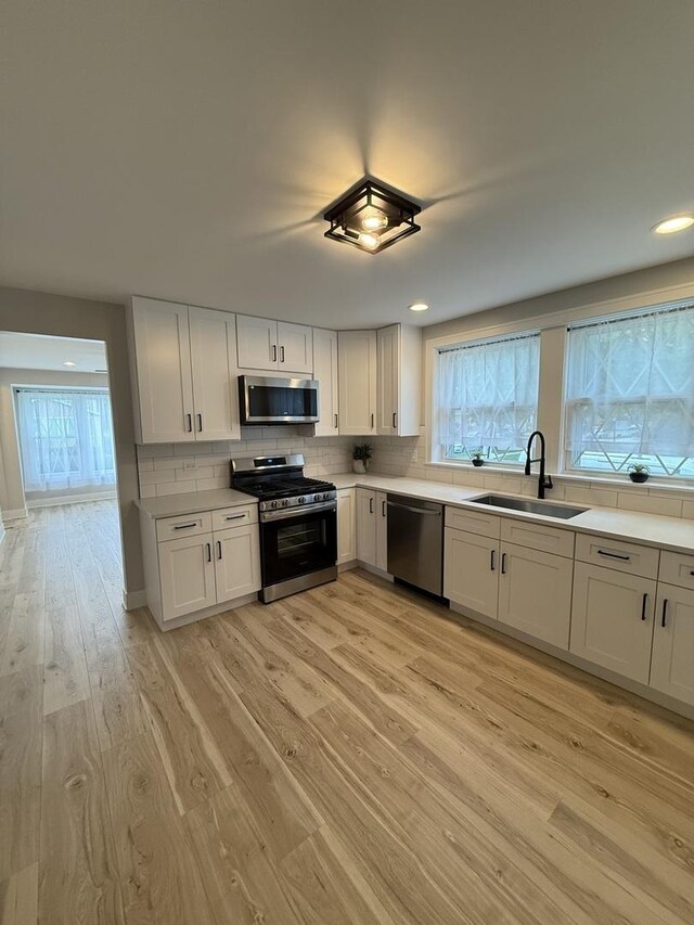 5301 S Mcvicker Ave, Chicago, IL 60638 - kitchen with appliances with stainless steel finishes, a sink, light wood-style floors, healthy amount of natural light, and recessed lighting