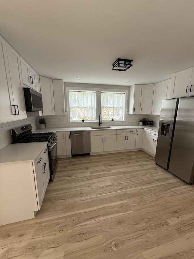 5301 S Mcvicker Ave, Chicago, IL 60638 - kitchen with appliances with stainless steel finishes, a sink, decorative backsplash, light countertops, and white cabinetry