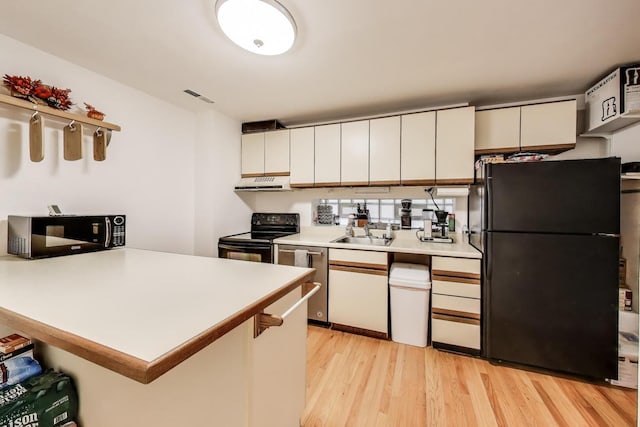 900 W Ainslie St Unit A, Chicago, IL 60640 - kitchen featuring black appliances, exhaust hood, a peninsula, light wood-style flooring, and light countertops