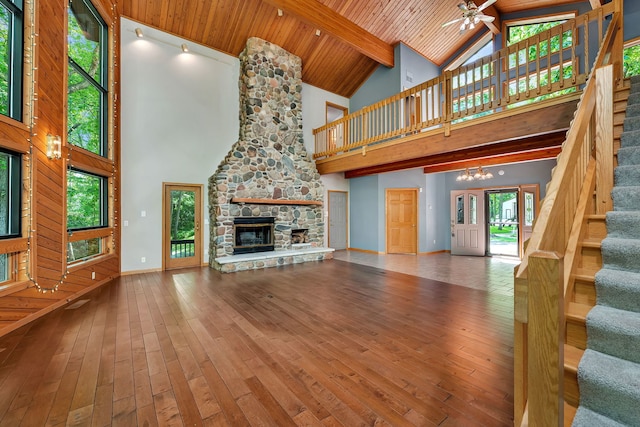 3085 W Southmor Rd, Morris, IL 60450 - unfurnished living room featuring high vaulted ceiling, stairway, a ceiling fan, a stone fireplace, and hardwood / wood-style flooring