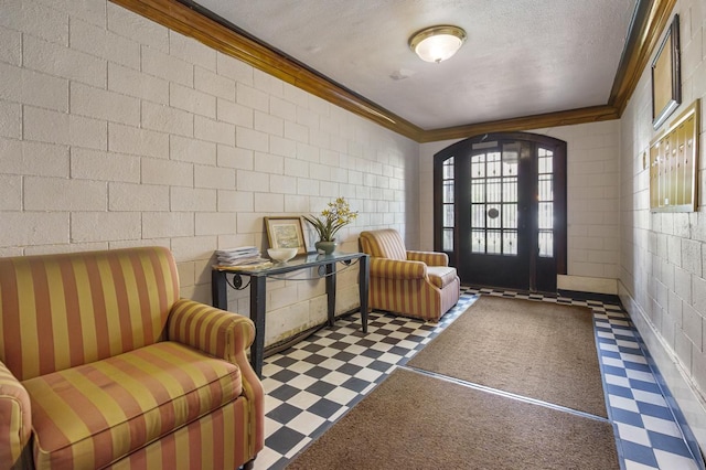 6801 S Crandon Ave Unit 1, Chicago, IL 60649 - foyer with tile patterned floors, ornamental molding, a textured ceiling, and concrete block wall