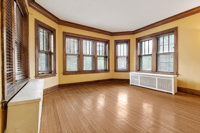 6801 S Crandon Ave Unit 1, Chicago, IL 60649 - spare room featuring radiator heating unit, ornamental molding, baseboards, and hardwood / wood-style flooring