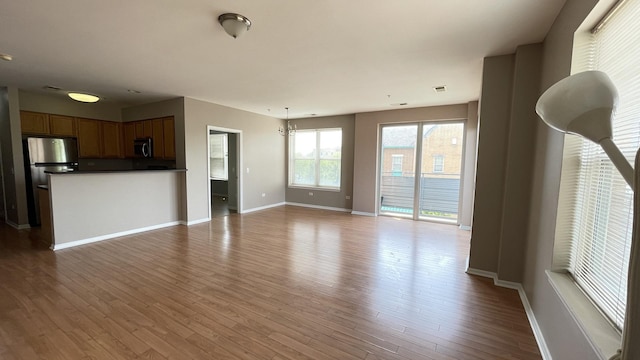 3522 S State St Unit 301, Chicago, IL 60609 - unfurnished living room featuring wood finished floors and baseboards