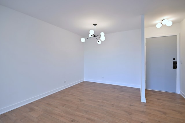 700 Wellington Ave Unit 315, Elk Grove Village, IL 60007 - unfurnished room featuring a chandelier, wood-type flooring, and baseboards