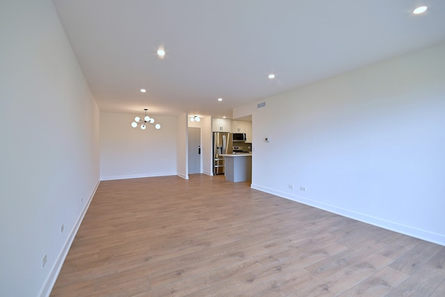 700 Wellington Ave Unit 315, Elk Grove Village, IL 60007 - unfurnished living room with a chandelier, light wood-style flooring, baseboards, and recessed lighting