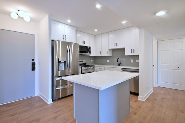 700 Wellington Ave Unit 315, Elk Grove Village, IL 60007 - kitchen with appliances with stainless steel finishes, light wood-style floors, baseboards, light stone counters, and a kitchen island