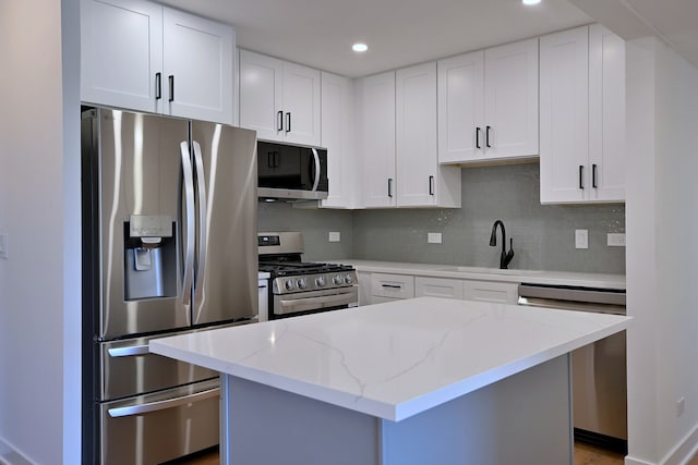 700 Wellington Ave Unit 315, Elk Grove Village, IL 60007 - kitchen featuring appliances with stainless steel finishes, a sink, tasteful backsplash, light stone counters, and white cabinets
