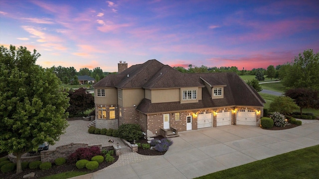 24355 S Arranmore Way, Frankfort, IL 60423 - view of front of property featuring driveway, a garage, stucco siding, a chimney, and brick siding