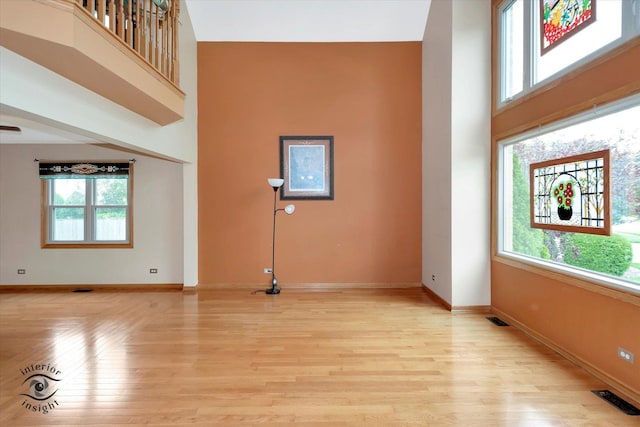 2985 Royal Ct, New Lenox, IL 60451 - unfurnished living room featuring light wood-style flooring, baseboards, and a high ceiling