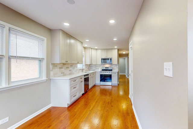521 Buckthorn Ln, Hillside, IL 60162 - kitchen with appliances with stainless steel finishes, a sink, tasteful backsplash, light countertops, and light wood-type flooring