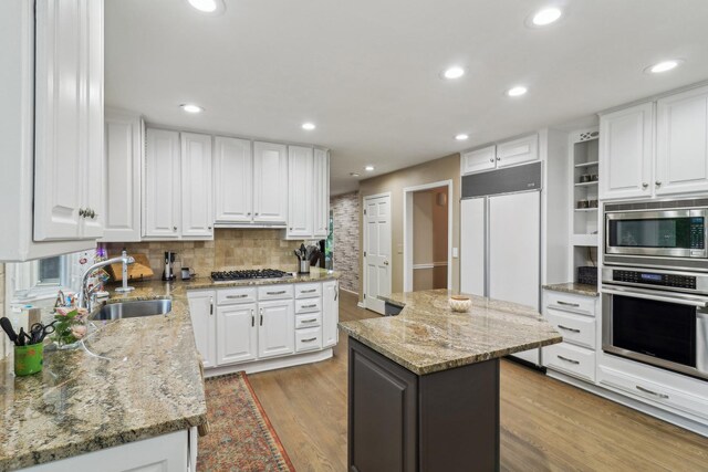 7316 Gleneagle Cir, Lakewood, IL 60014 - kitchen with appliances with stainless steel finishes, a sink, light wood-type flooring, white cabinetry, and recessed lighting