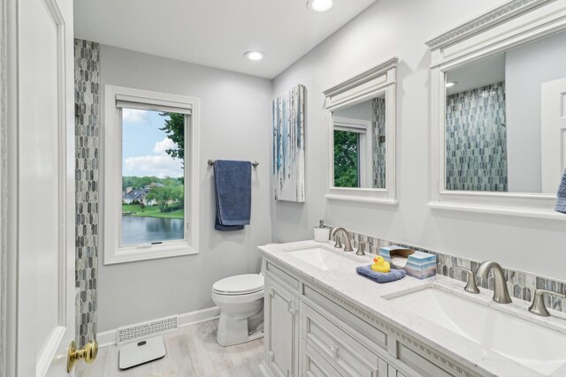 7316 Gleneagle Cir, Lakewood, IL 60014 - bathroom featuring double vanity, toilet, baseboards, wood finished floors, and recessed lighting
