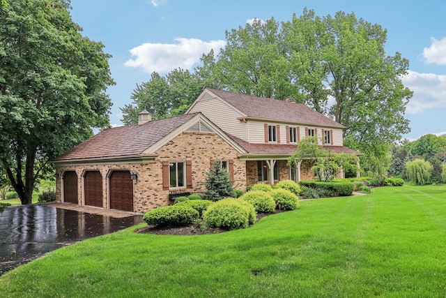 7316 Gleneagle Cir, Lakewood, IL 60014 - view of front of property with brick siding, a chimney, an attached garage, driveway, and a front lawn