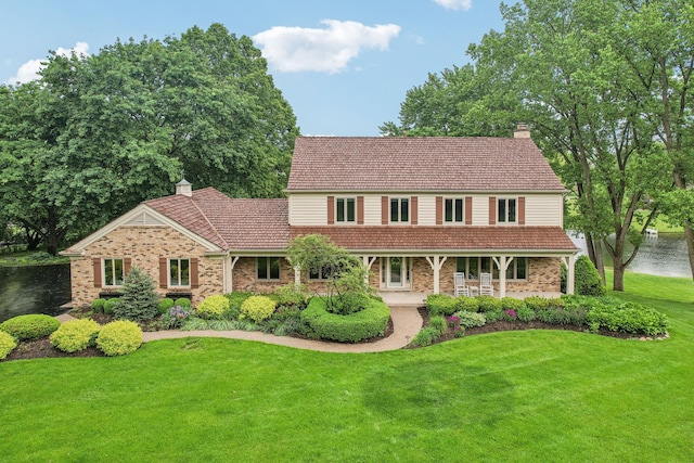 7316 Gleneagle Cir, Lakewood, IL 60014 - view of front facade featuring a chimney, a front yard, brick siding, and a porch