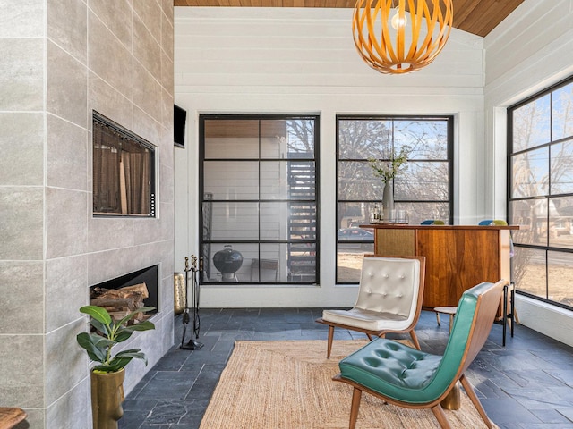 527 N Ellsworth St, Naperville, IL 60563 - living area featuring a tiled fireplace, stone tile floors, and wooden ceiling