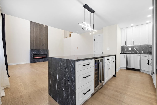 676 E Whispering Oaks Ct, Palatine, IL 60074 - kitchen with stainless steel dishwasher, beverage cooler, light wood-type flooring, a high end fireplace, and decorative backsplash