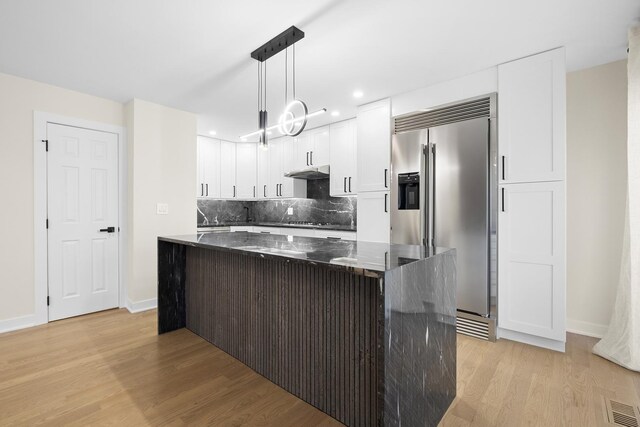 676 E Whispering Oaks Ct, Palatine, IL 60074 - kitchen with high end refrigerator, light wood-style floors, decorative backsplash, a center island, and dark stone countertops