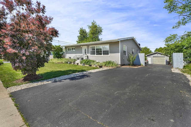 127 Saint Joseph Ave, Joliet, IL 60436 - view of front facade featuring an outdoor structure, a detached garage, asphalt driveway, and a front lawn