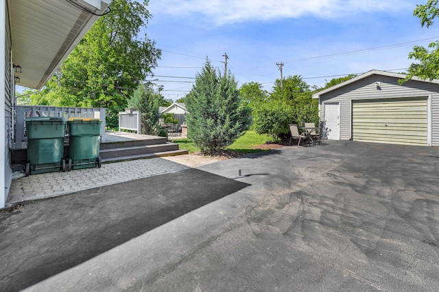 127 Saint Joseph Ave, Joliet, IL 60436 - view of patio featuring an outdoor structure, a garage, asphalt driveway, and a deck