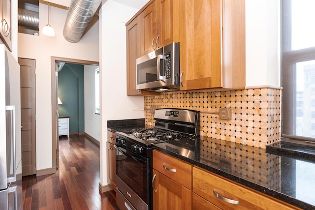 212 N Center St Unit 502, Bloomington, IL 61701 - kitchen featuring black range with gas stovetop, stainless steel microwave, dark wood-style floors, tasteful backsplash, and dark stone countertops