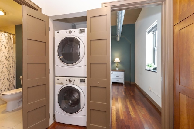 212 N Center St Unit 502, Bloomington, IL 61701 - laundry area with stacked washer and clothes dryer, wood finished floors, and baseboards