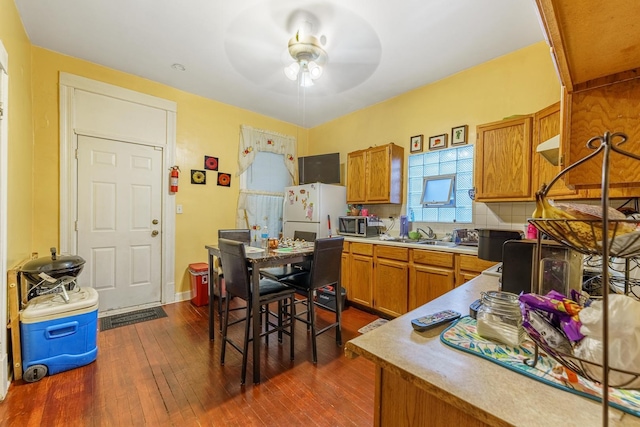 1826 N Keeler Ave, Chicago, IL 60639 - kitchen featuring brown cabinetry, ceiling fan, dark wood finished floors, stainless steel microwave, and freestanding refrigerator