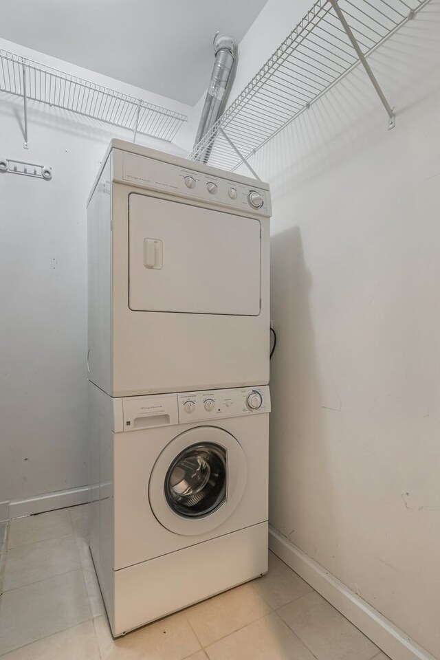 828 N California Ave Unit 3, Chicago, IL 60622 - washroom featuring stacked washer / drying machine, light tile patterned floors, and baseboards