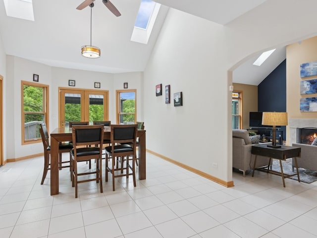 27213 N Fairfield Rd, Wauconda, IL 60084 - dining room with a skylight, healthy amount of natural light, arched walkways, a lit fireplace, and high vaulted ceiling