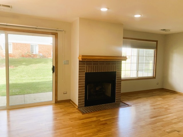 308 Ashbury Ct Unit 1515-1, Roselle, IL 60172 - unfurnished living room featuring light wood-style flooring, a brick fireplace, and recessed lighting