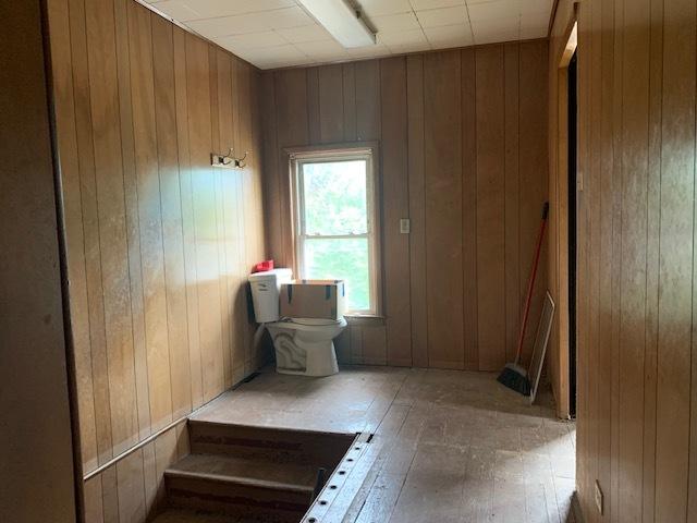 1013 Guion St, Ottawa, IL 61350 - bathroom featuring toilet, wood walls, and hardwood / wood-style flooring