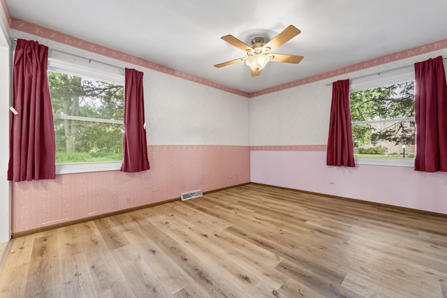 132 Pratt Blvd, Roselle, IL 60172 - empty room with wood finished floors, healthy amount of natural light, wallpapered walls, a ceiling fan, and baseboards