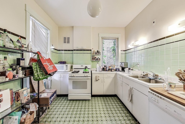 5357 N Wayne Ave, Chicago, IL 60640 - kitchen with white appliances, tile walls, a sink, a wainscoted wall, and light countertops