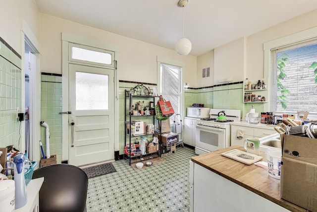 5357 N Wayne Ave, Chicago, IL 60640 - kitchen featuring white appliances, butcher block counters, tile walls, hanging light fixtures, and wainscoting
