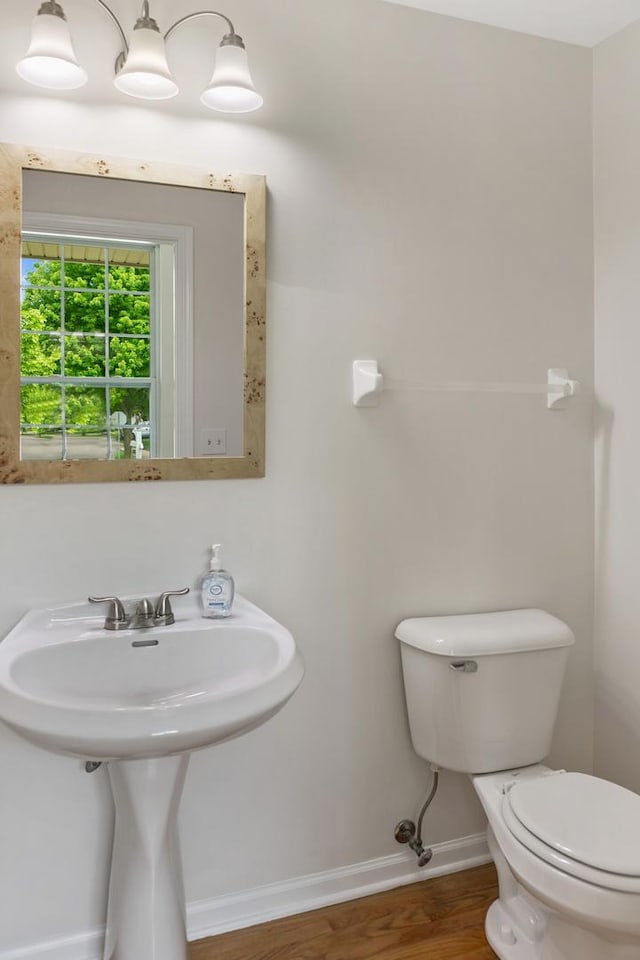 240 Regency Blvd, Sugar Grove, IL 60554 - half bathroom featuring toilet, baseboards, wood finished floors, and a sink