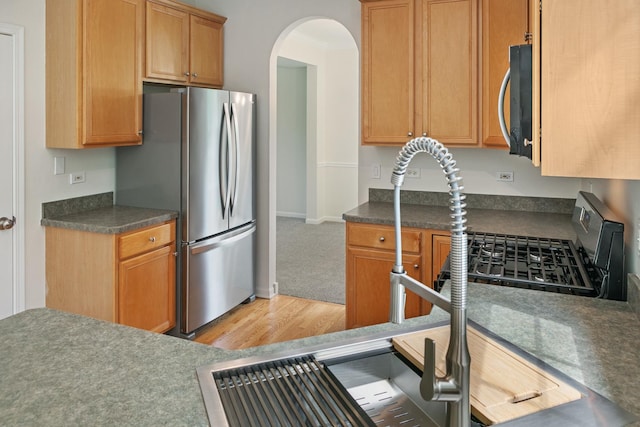 240 Regency Blvd, Sugar Grove, IL 60554 - kitchen featuring freestanding refrigerator, arched walkways, light wood finished floors, gas stove, and dark countertops