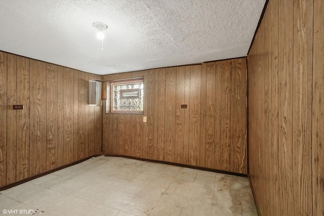 2630 N Austin Ave, Chicago, IL 60639 - spare room with light floors, wooden walls, and a textured ceiling