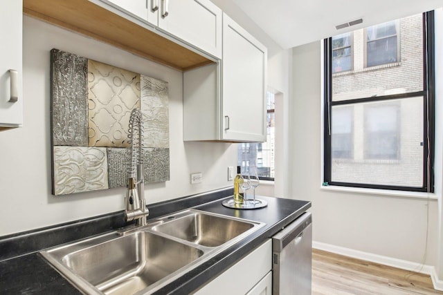 740 S Federal St Unit 804, Chicago, IL 60605 - kitchen featuring stainless steel dishwasher, white cabinets, light wood-style flooring, dark countertops, and baseboards