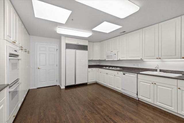380 Green Bay Rd Unit 4D, Winnetka, IL 60093 - kitchen with white appliances, a skylight, a sink, dark wood-style floors, and dark countertops