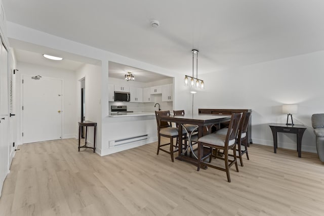 141 N La Grange Rd Unit 303, La Grange, IL 60525 - dining room featuring light wood-style flooring, baseboard heating, and baseboards